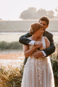 Professional videography couple embraces in scenic outdoor setting