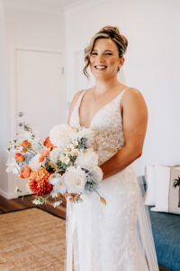 Professional videography bride holding bouquet in wedding dress indoors