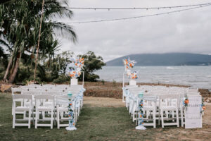 Professional videography, photography, and drone footage at beach wedding ceremony setup by the ocean.