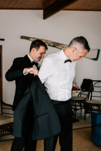 Professional videography capturing groom dressing in sharp suit