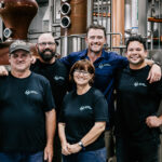 Professional videography team in distillery setting smiling