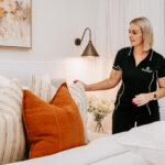 The Stylist arranging cushions on a bed