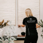 The Stylist arranging artwork above a console table