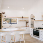 Styled kitchen with timber island and white stools