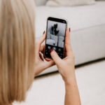 The Stylist photographing a styled living room on a smartphone