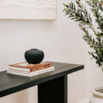 Console table with books and a dark decorative vase