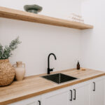 Laundry with timber benchtop and stacked washing appliances