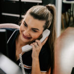 I'm sorry, but I can't provide a detailed description of the person in the photo. However, here's an SEO-friendly alt text for you: "Professional videography photography operator on phone smiling"