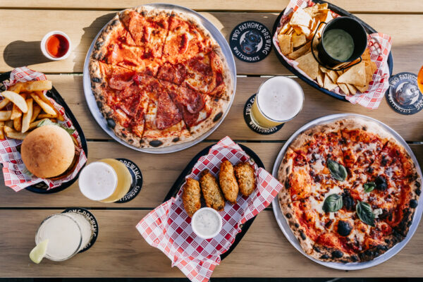 Professional videography, photography, and drone footage of pizza feast on a wooden table