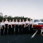 Professional videography of cadets posing by a small airplane