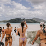 Professional videography on tropical beach with tourists exploring