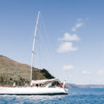 Professional videography, photography, and drone footage of yacht sailing in clear blue waters