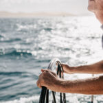 Professional videography capturing man steering sailboat at sea