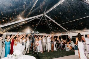 Professional videography guests celebrating under lit canopy