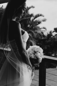 Professional videography capturing bride with bouquet on balcony