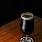 Professional videography glass of dark stout on table