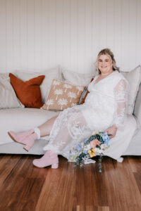 Professional videography, photography, and drone footage of a woman sitting on a sofa with a floral dress.