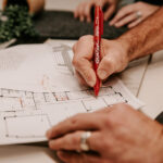 Professional videography planning on blueprint with red pen