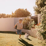 Professional videography captures child playing with dog outdoors