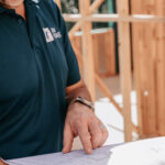 Professional videography man reviewing construction blueprints