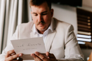 Professional videography man reading card in beige suit