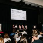 Professional videography, photography, and drone footage of a panel discussion event with an engaged audience.