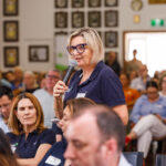 Professional videography event speaker in a crowded seminar hall