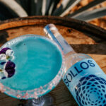 Professional videography close-up of blue cocktail and bottle