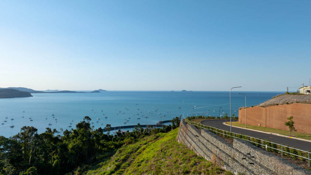 Professional videography, photography, and drone footage of a coastal landscape with a winding road and sea views