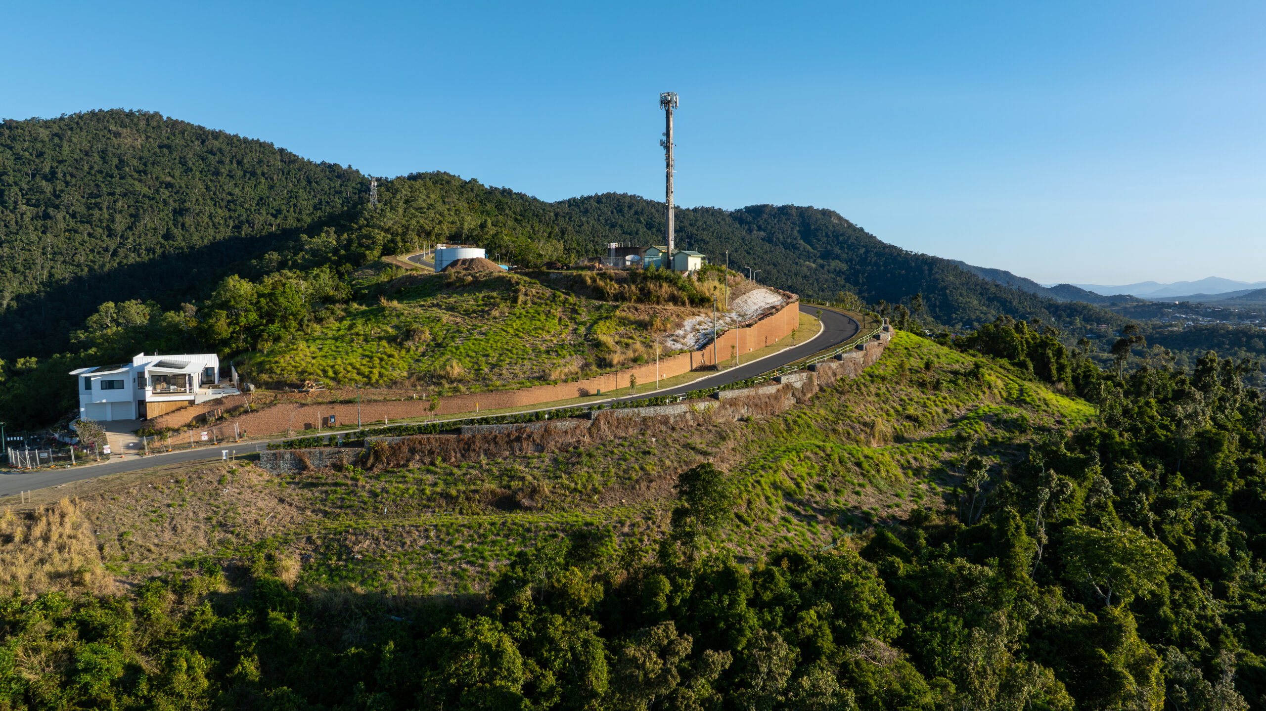 TDM aerial photograph of Airlie Summit’s hillside roads and retaining walls beside forest