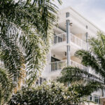Boathouse Apartments balconies behind tropical landscaping