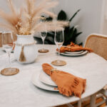 Dining table set with plates and orange napkins at 208 Boathouse