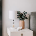 Bedside table with a lamp and flowers at 208 Boathouse