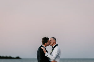 Professional videography, photography, and drone footage capture romantic couple at sunset beach.