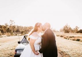 Bride & Groom kiss in front of car