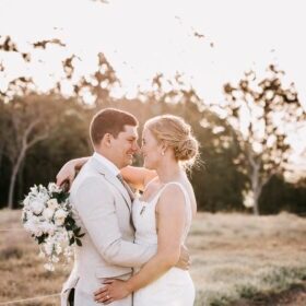 Bride & Groom embrace with sun behind